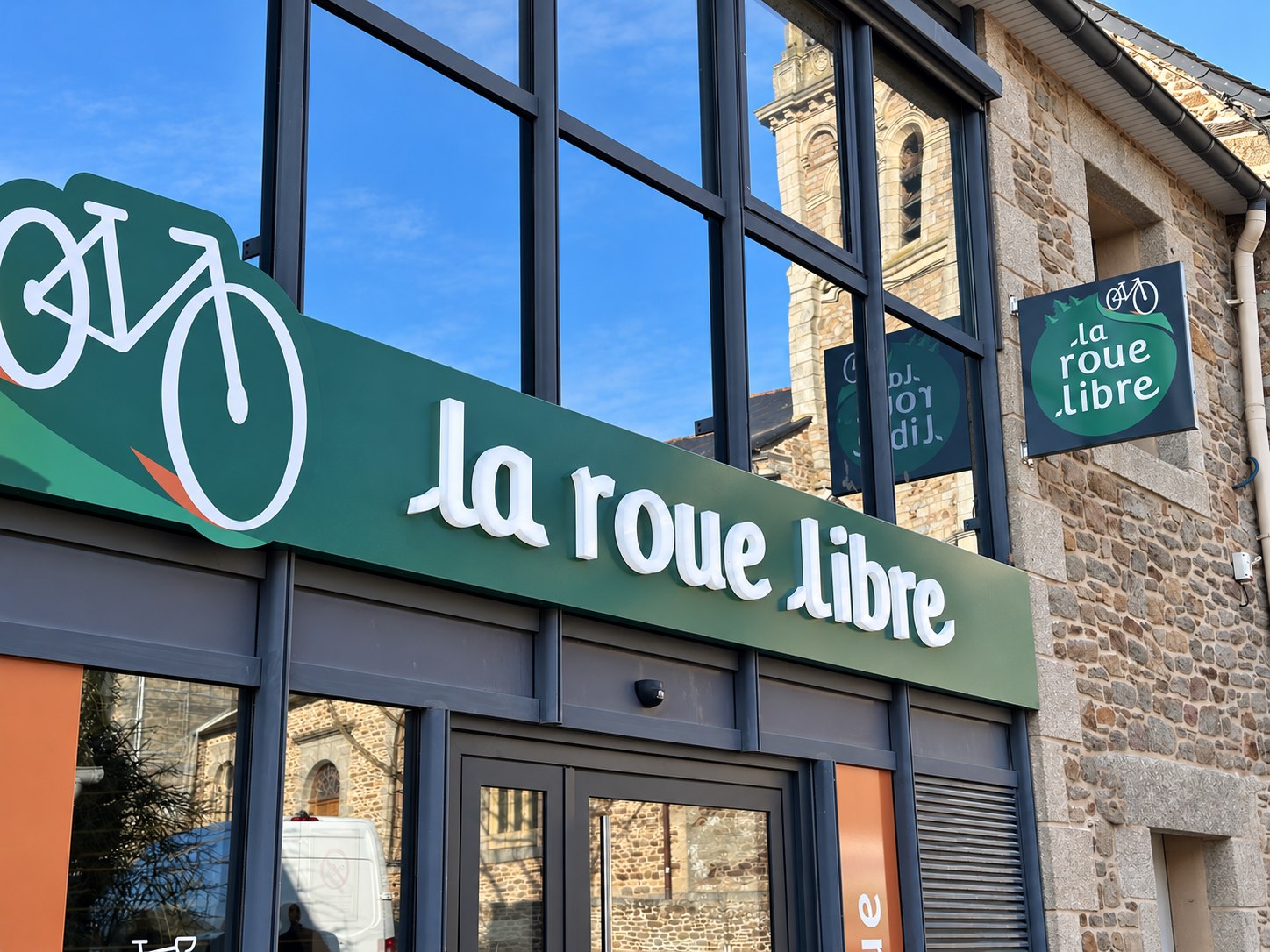 La Roue Libre : lettres PMMA lumineuses LED sur bandeau vert et enseigne drapeau