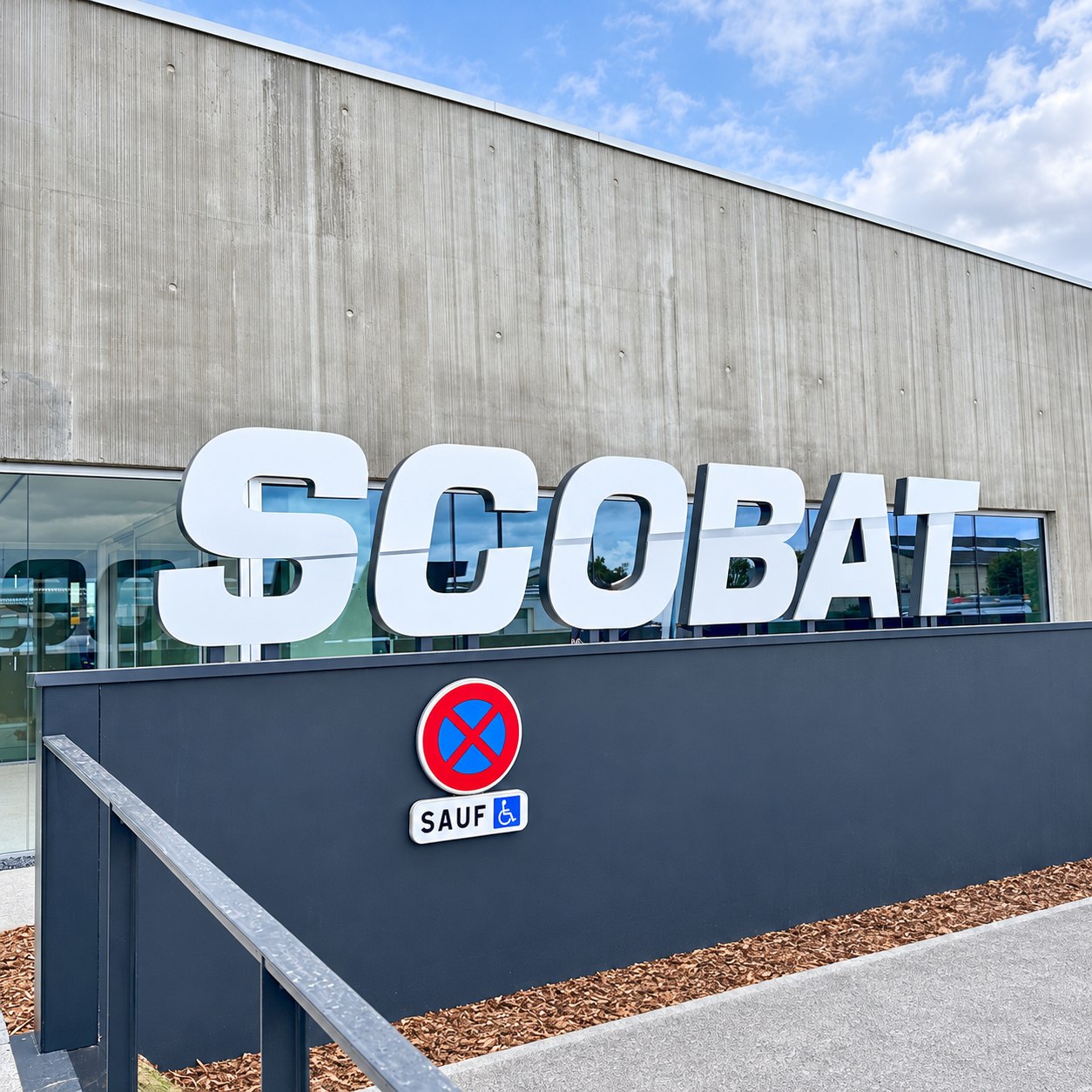 Enseigne lumineuse Scobat en grandes lettres boîtiers blanches sur la façade