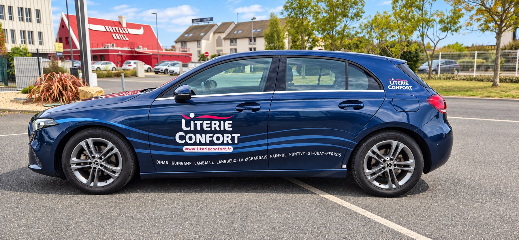 Voiture bleue Literie Confort avec logo blanc et coordonnées sur les portières