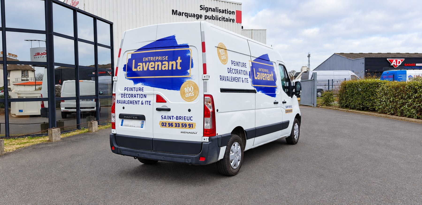 Fourgon blanc Lavenant avec logo bleu et jaune et coordonnées à l’arrière