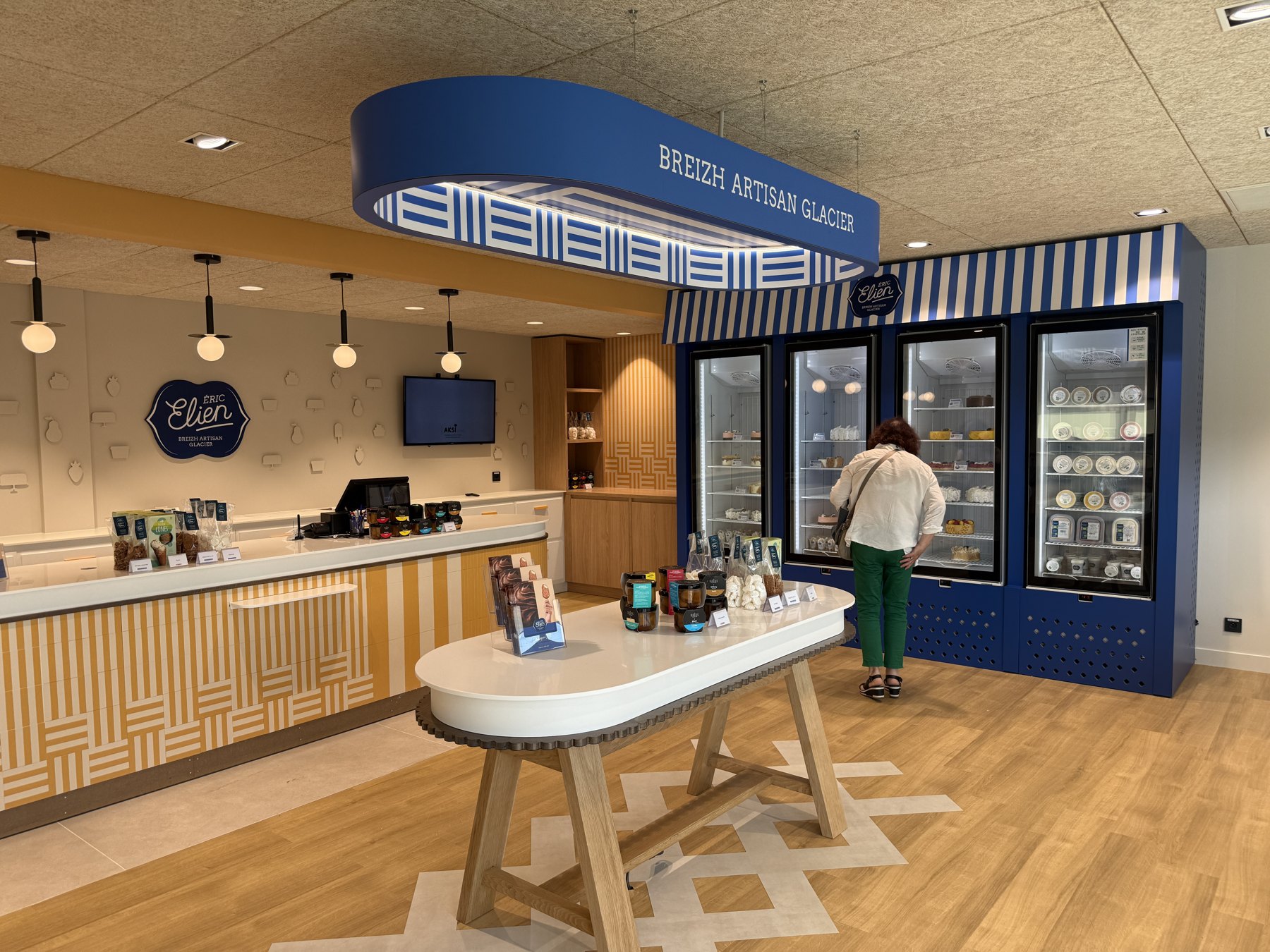 Boutique Éric Elien : logo mural, décors en PVC en relief, luminaire suspendu et habillage des vitrines.