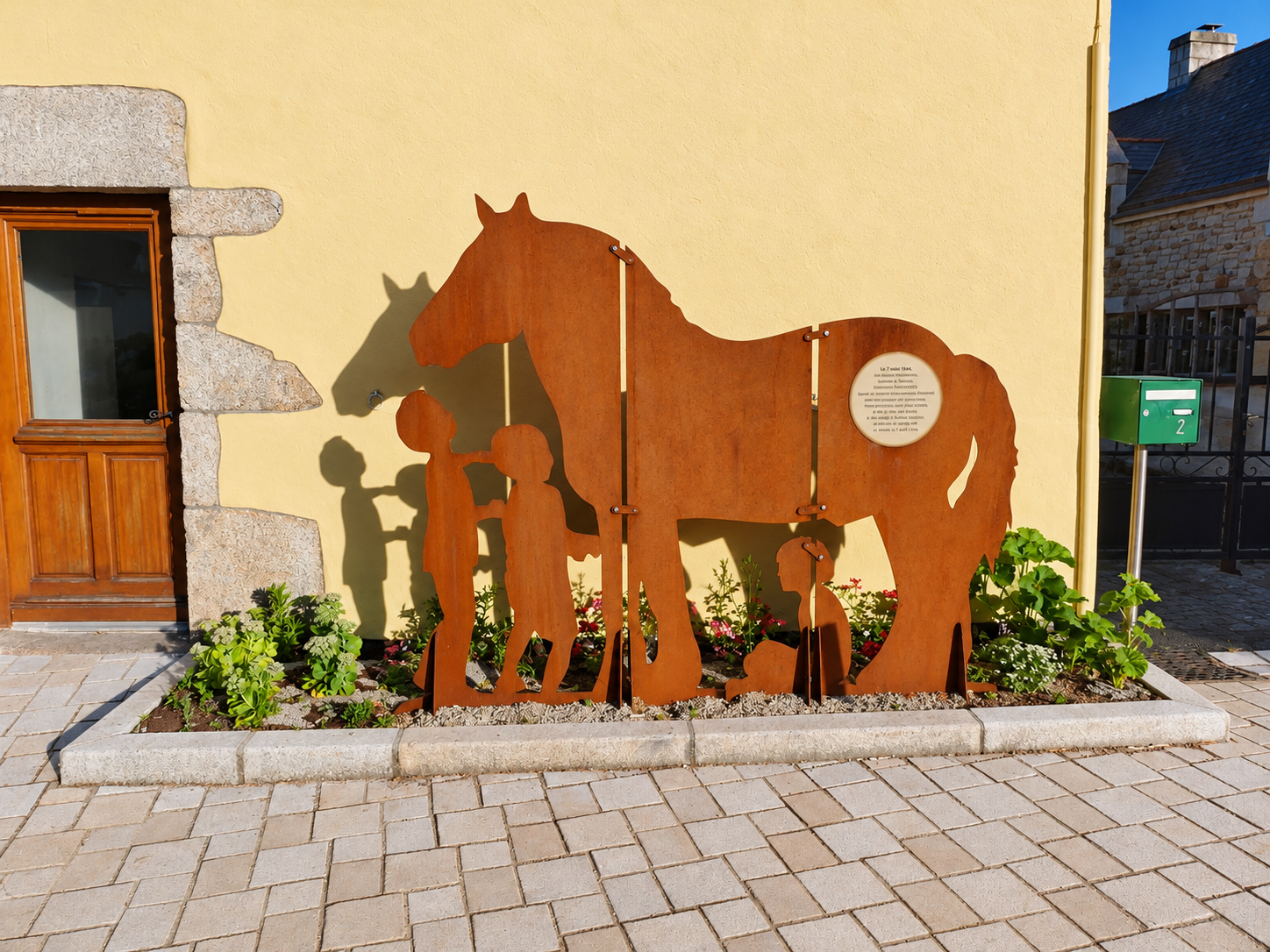 Décor découpé représentant un cheval et des personnages devant un bâtiment.
