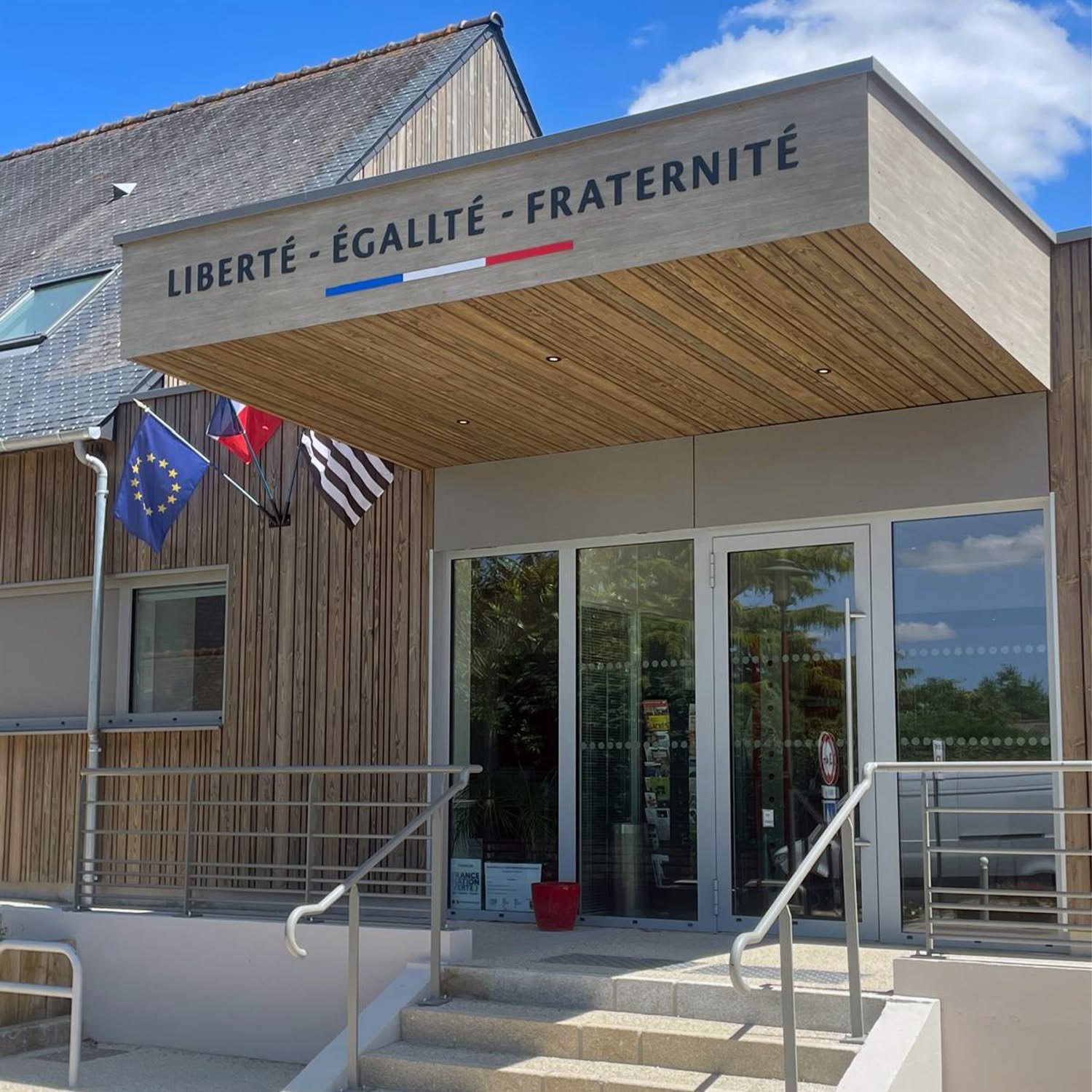 Devise Liberté Égalité Fraternité avec symbole tricolore au-dessus d’une entrée publique.