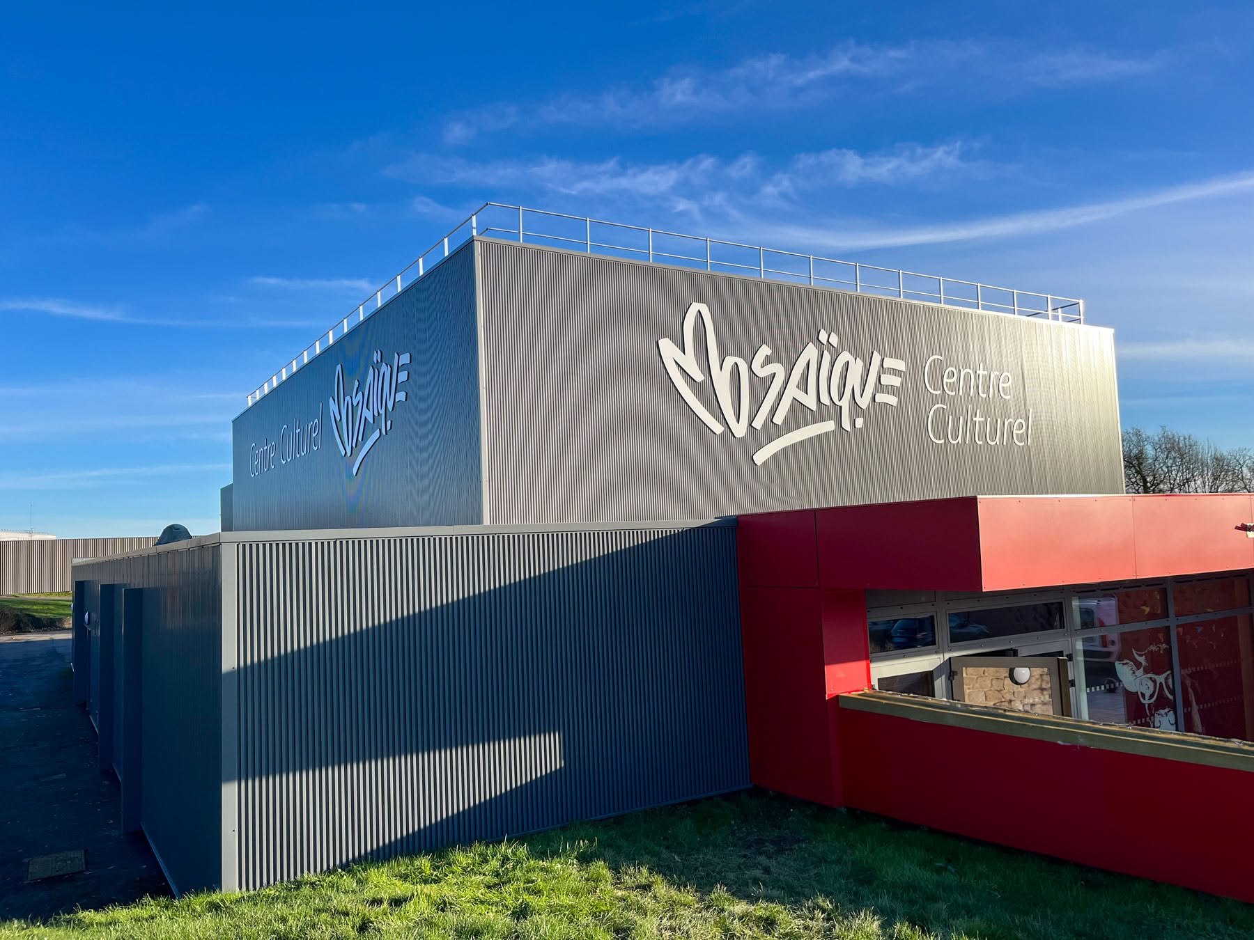 Enseigne Mosaïque sur le bardage d’un centre culturel.