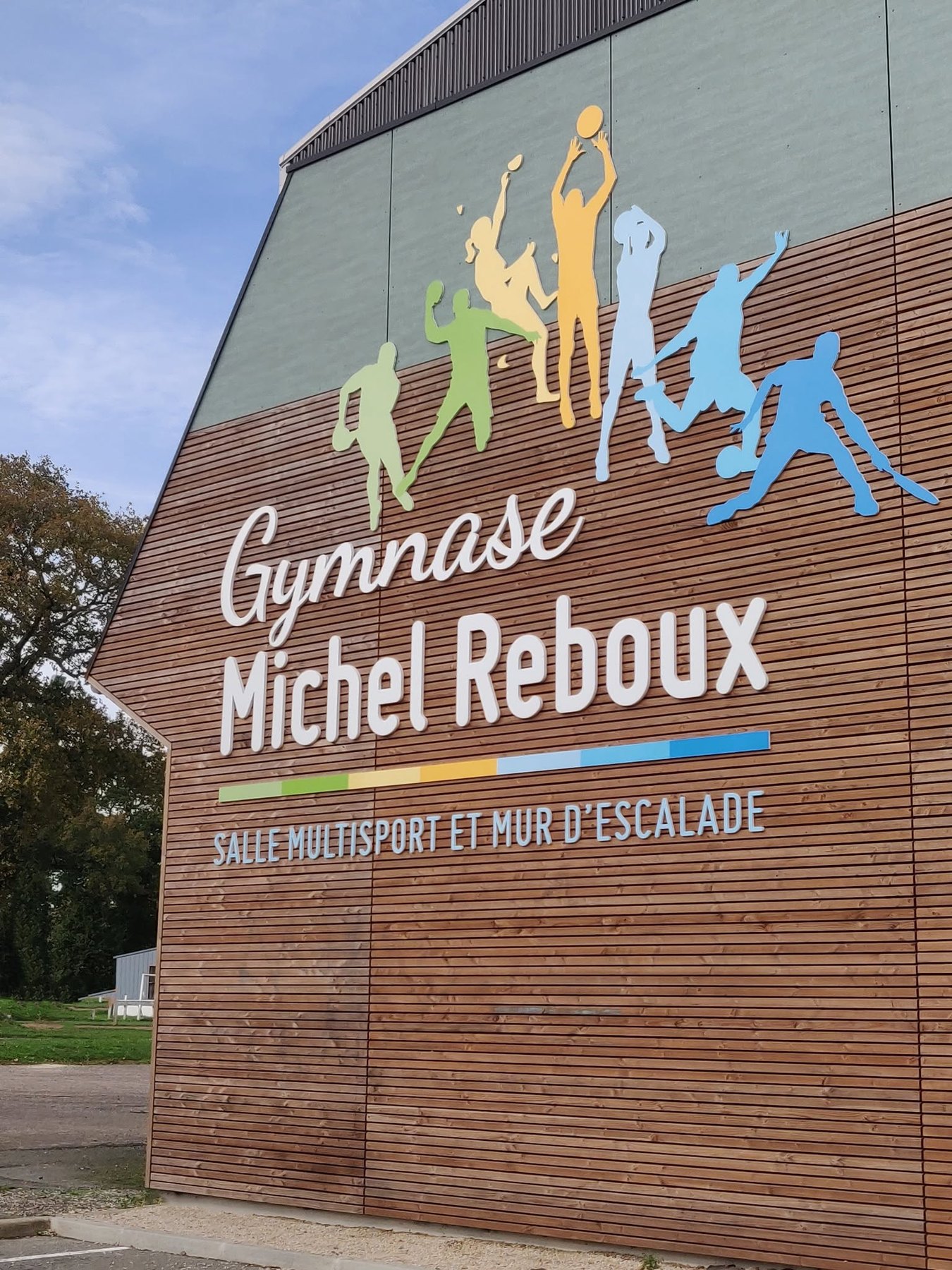 Grand marquage du Gymnase Michel Reboux sur façade de bâtiment sportif.