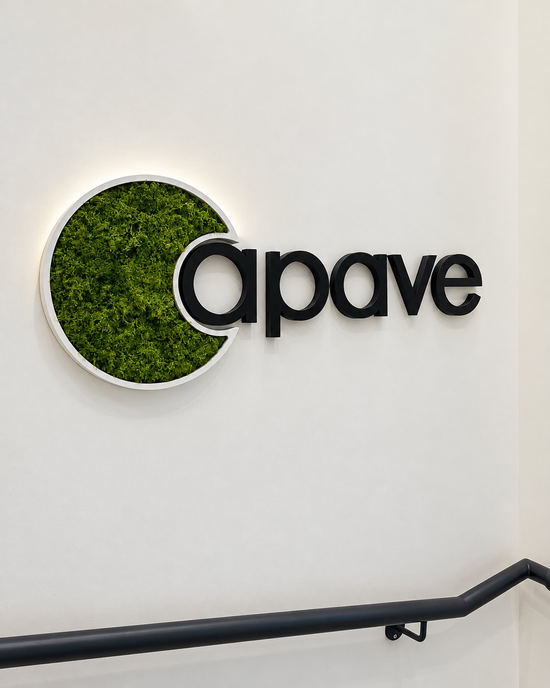 Logo Apave en relief sur un mur blanc avec élément circulaire vert