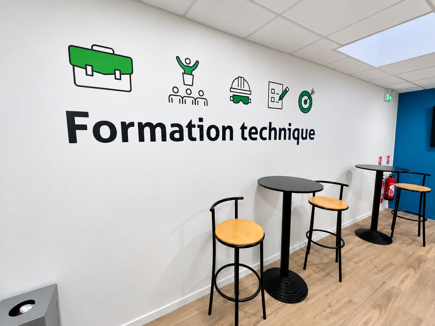 Inscription Formation technique et pictogrammes verts sur un mur blanc